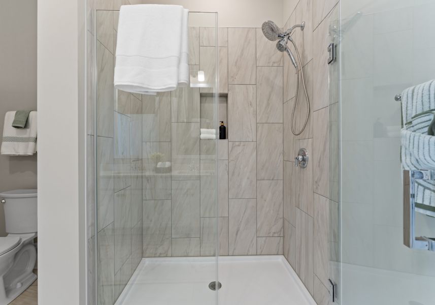 spacious walk-in shower with a built-in nook shelf.