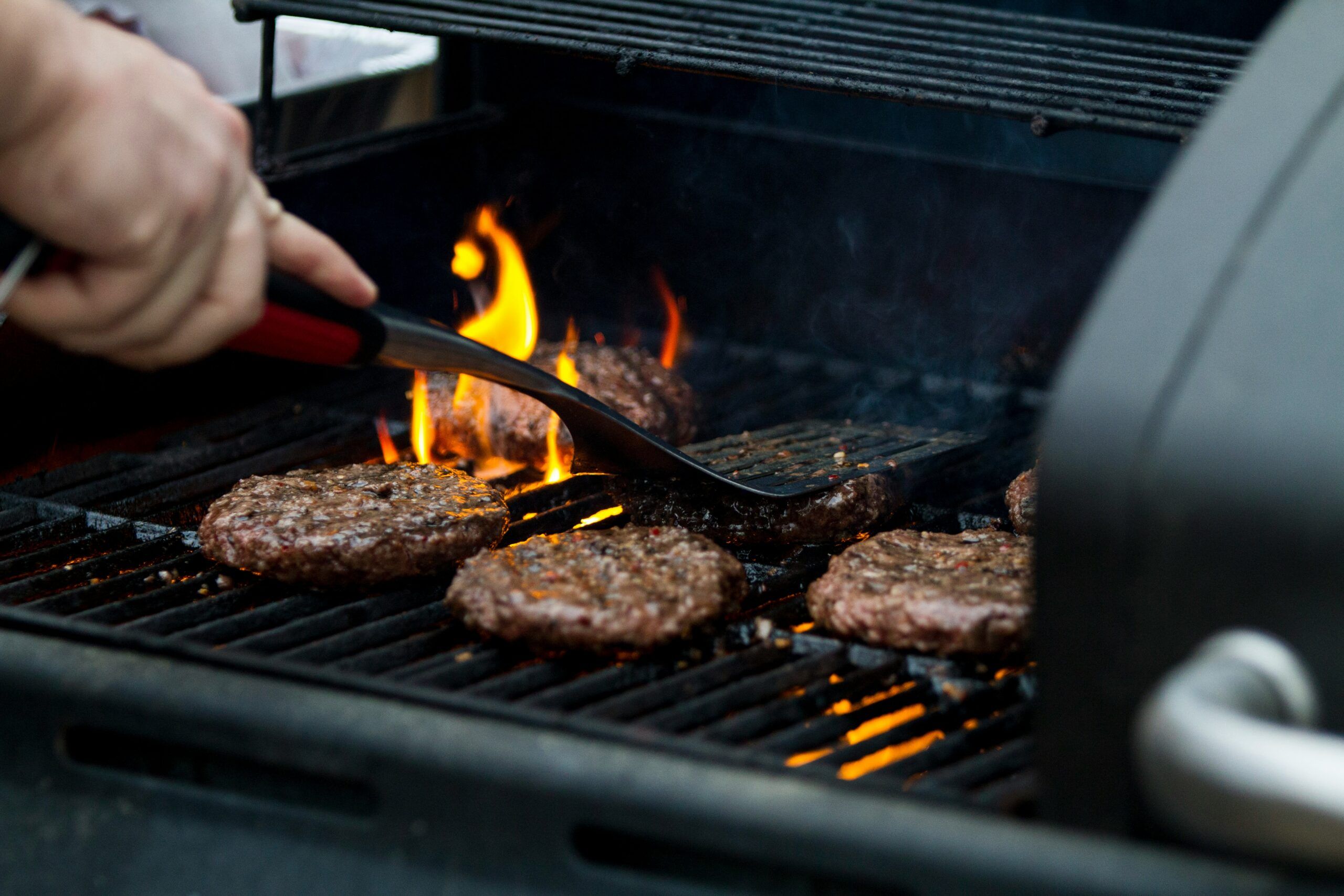 A person using the outdoor grill at The Lodges at Fort Mill.