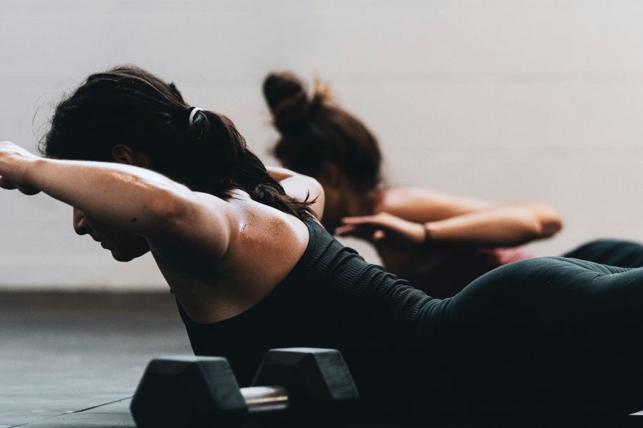 women working out at The Lodges at Fort Mill laying on the ground doing an exercise
